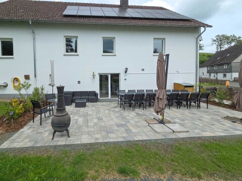 Gro&szlig;er Garten mit gro&szlig;er Terrasse, vielen Tischen und Stühlen sowie einem Grill   Ferienhaus Haus am Bach   Referinghausen